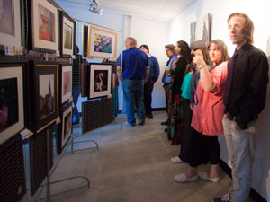 Members of the general public admiring the work of our Photography Beyond the Basics class at a gallery art show